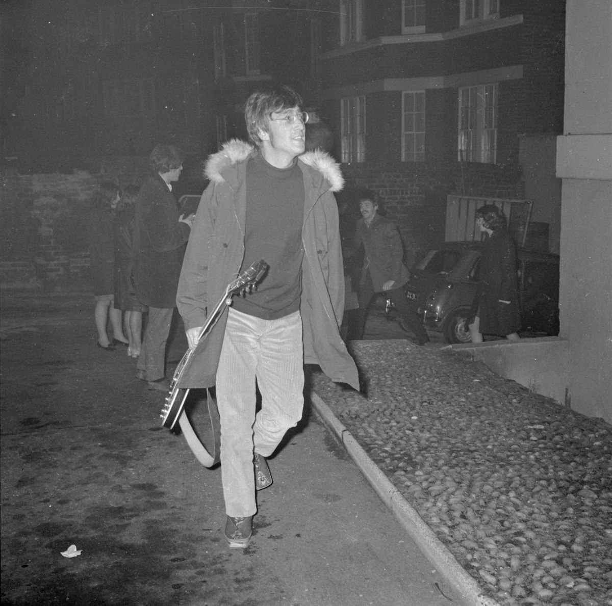 1966: John Lennon kommt bei den EMI Studios auf der Abbey Road in London an - sein Instrument hat er direkt mitgebracht. (Photo by Larry Ellis/Express/Getty Images)